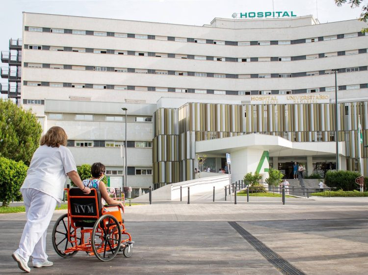 Paciente en silla de ruedas en las inmediaciones del Hospital Universitario Virgen Macarena scaled e1755604385656